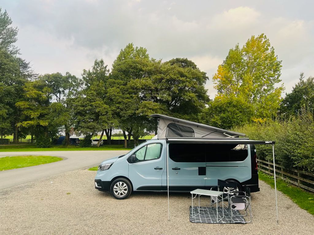 Maisie-Moo campervan with awning out under trees
