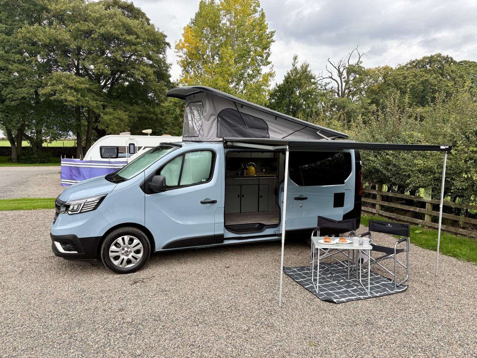 Maisie-Moo campervan with awning and outdoor dining set up